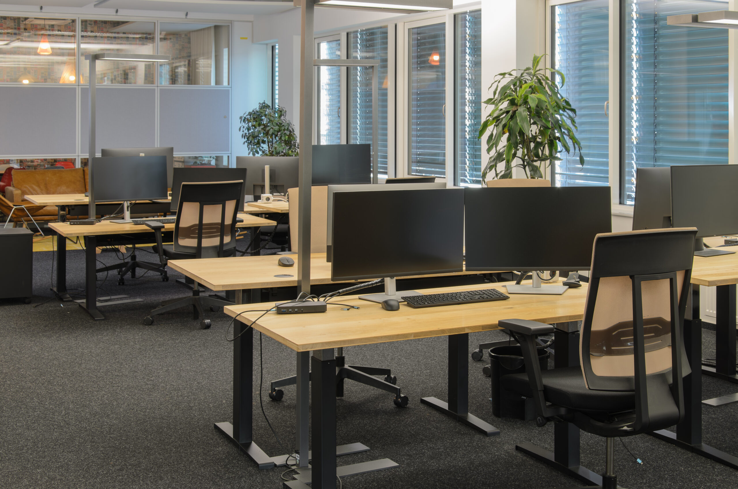 schoon kantoor met twee schermen per bureau en bureaustoelen