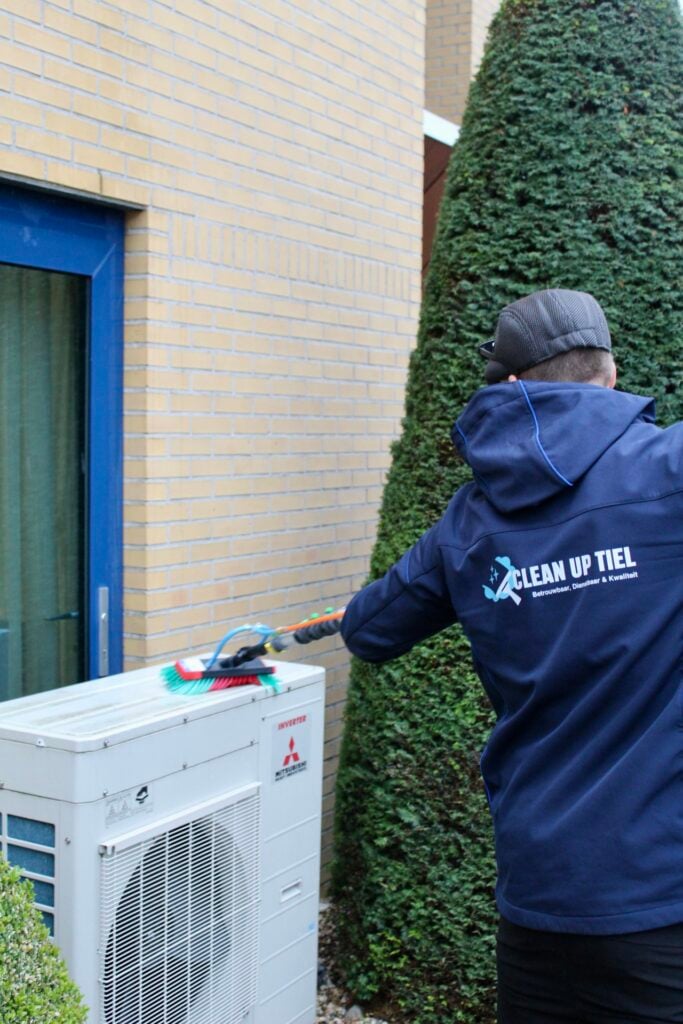 Schoonmaker wast airco buiten kantoorpand